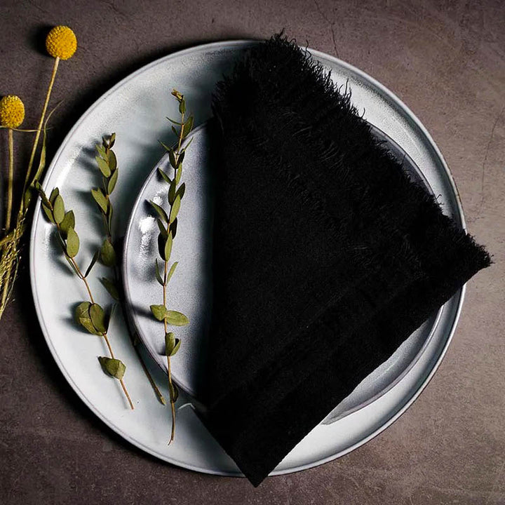Black cotton gauze napkin folded on ceramic plate with botanical accents, 41 × 41cm – soft and elegant for Scandinavian-style tables.