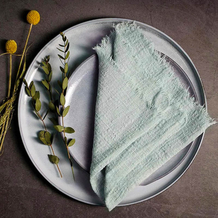 Sage Green cotton gauze napkin folded on ceramic plate with botanical accents, 41 × 41cm – soft and elegant for Scandinavian-style tables.