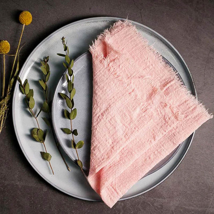 Pink cotton gauze napkin folded on ceramic plate with botanical accents,16 x 16 inches – soft and elegant for Scandinavian-style tables.