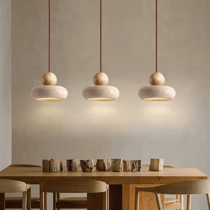 Trio of NATUR pendant lights with agate-inspired stone design illuminating wooden dining table