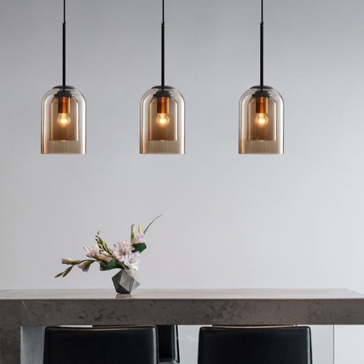 Three amber glass pendant lamps above a dining table