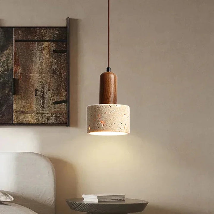 Pendant light with wooden top and concrete base in a room setting.