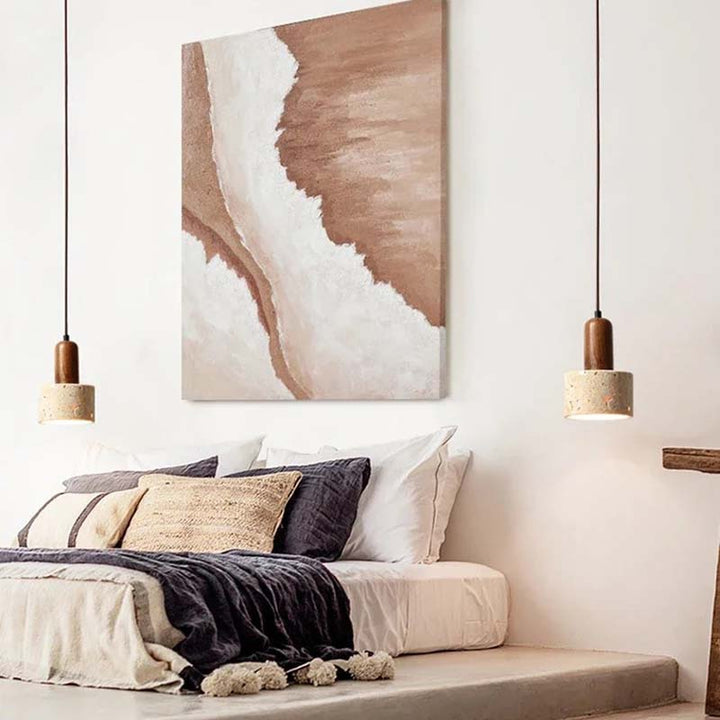 Bedroom with abstract wall art, pillows, and two natural stone bedside pendant lights.