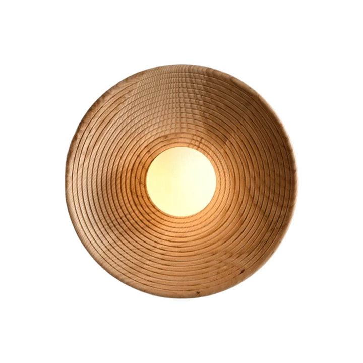 Top-down view of the Nordic natural wood wall lamp with concentric carved wood rings and a glowing frosted glass centre.
