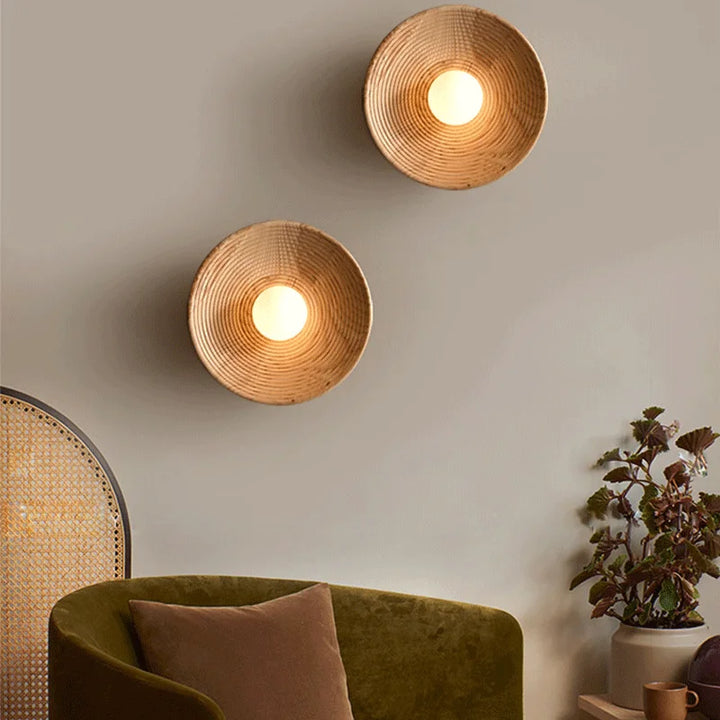 Two SFARISK wall lamps styled vertically on a neutral wall above a green velvet chair and sideboard