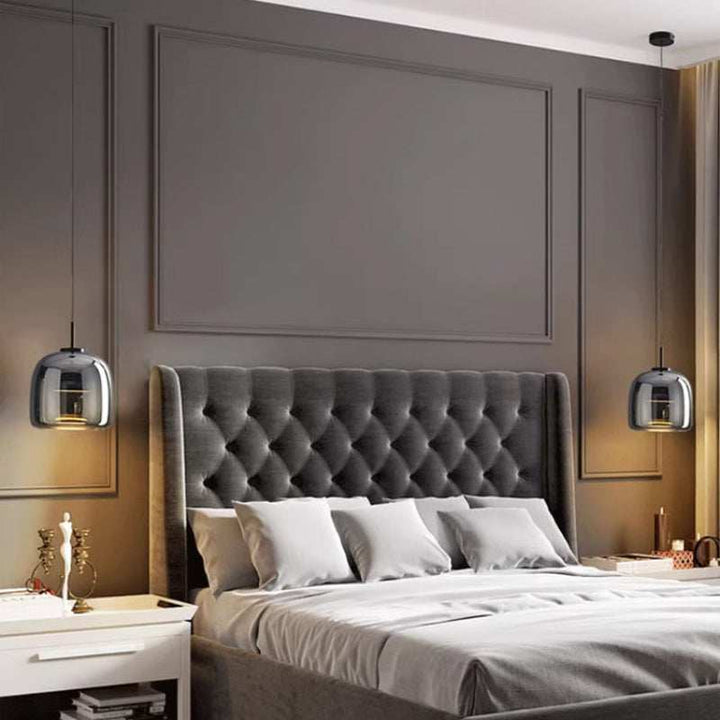 Modern bedroom with grey tufted headboard and decorative wall panels and nordic glass pendant lights