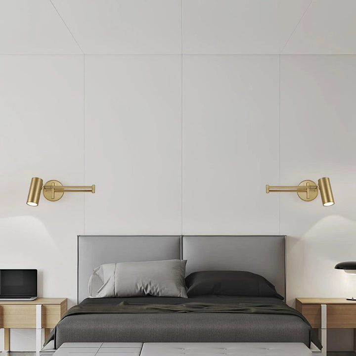 Modern bedroom with gray bed, wooden nightstands, and gold wall sconces.