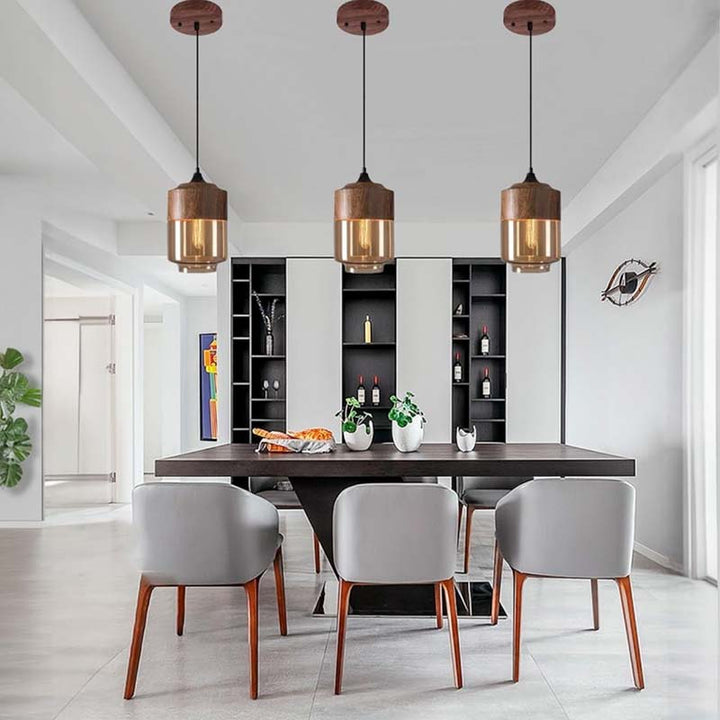 Modern dining area with a dark wooden table and gray chairs, featuring pendant lights and a white wall.