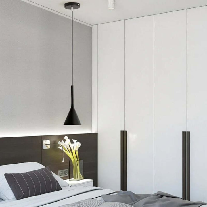 Modern bedroom with a bed, headboard, and pendant light.