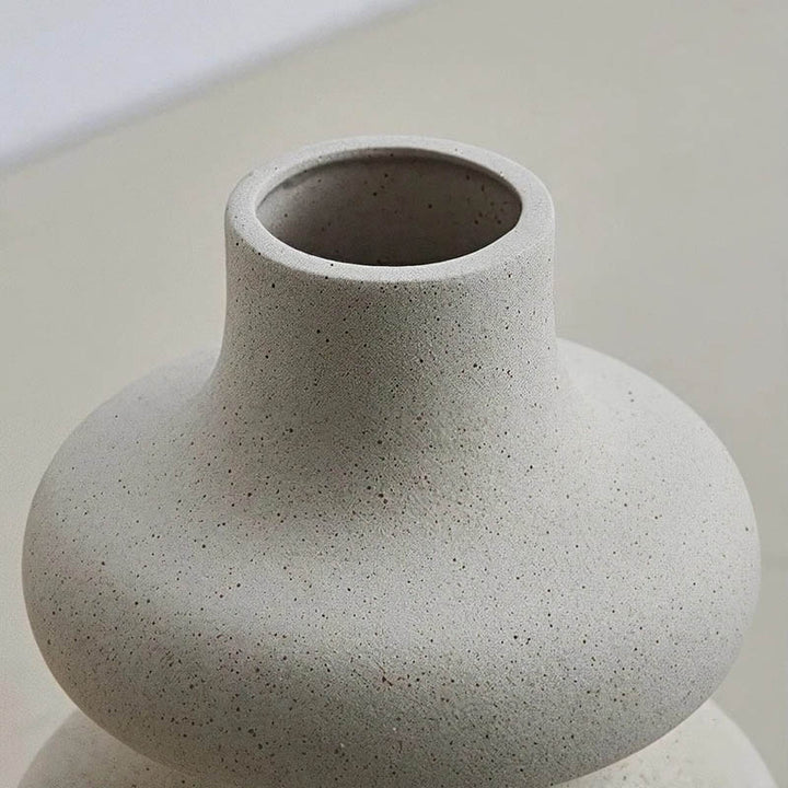 Textured ceramic vase top detail showing natural speckled glaze and smooth narrow opening