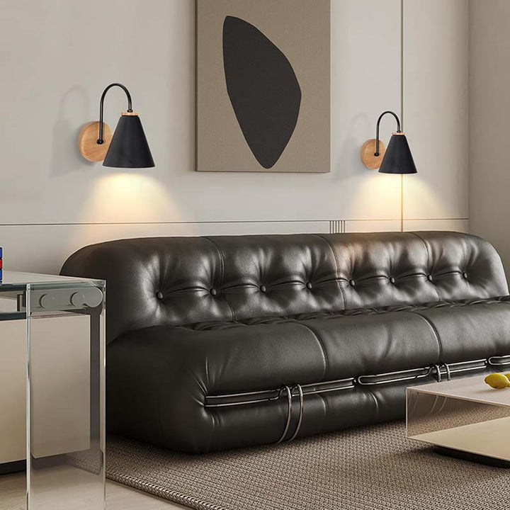 Modern living room with a black leather sofa, abstract art, and nordic wall lamps.