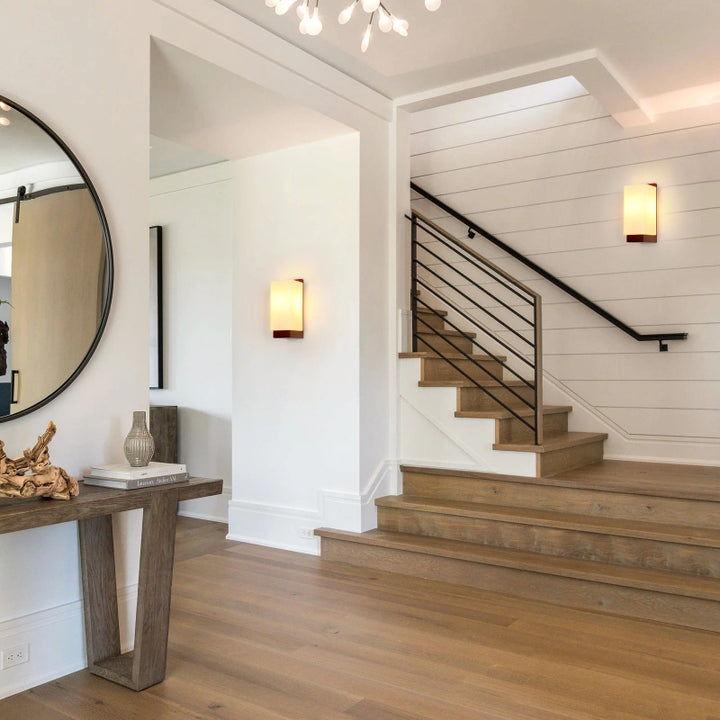 Staircase in a home with wooden flooring and nordic wood wall lights.