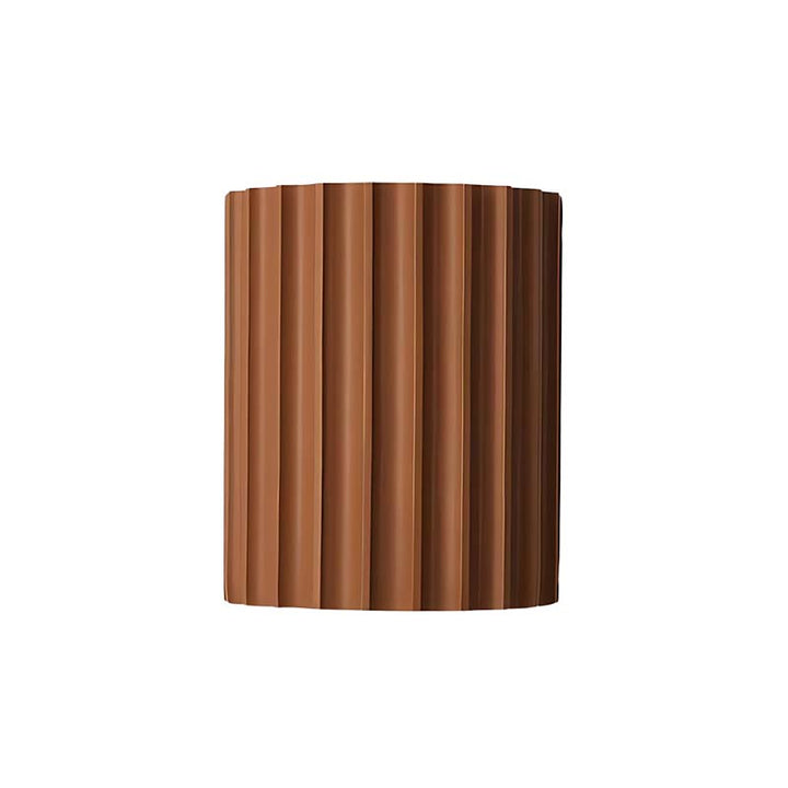 Modern orange wall sconce with a ribbed design on a white background