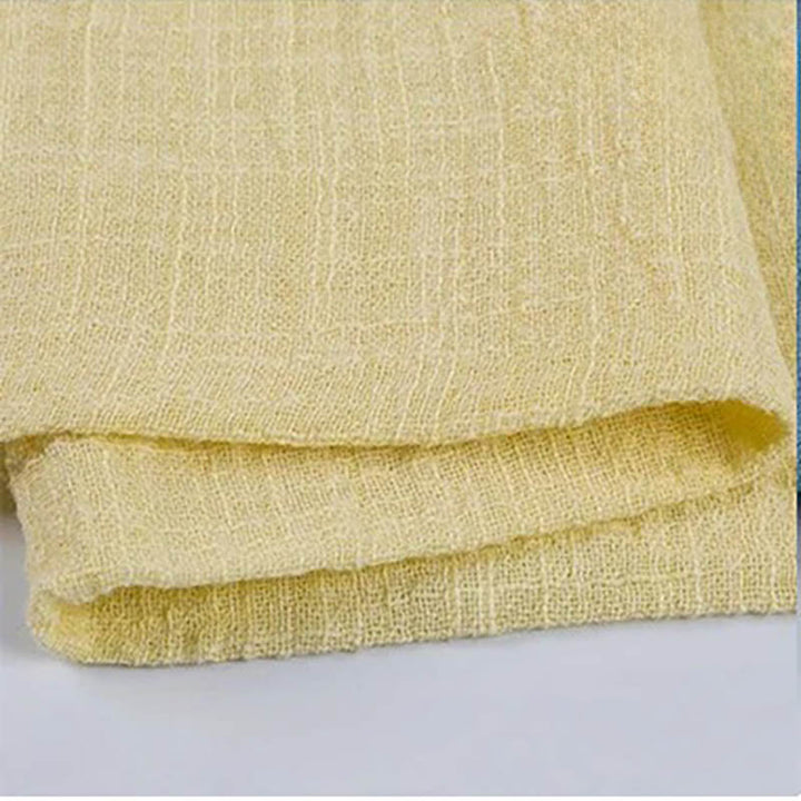 Folded pastel yellow cotton napkin for Weddings and Elegant uk Dining Decor on the white table.