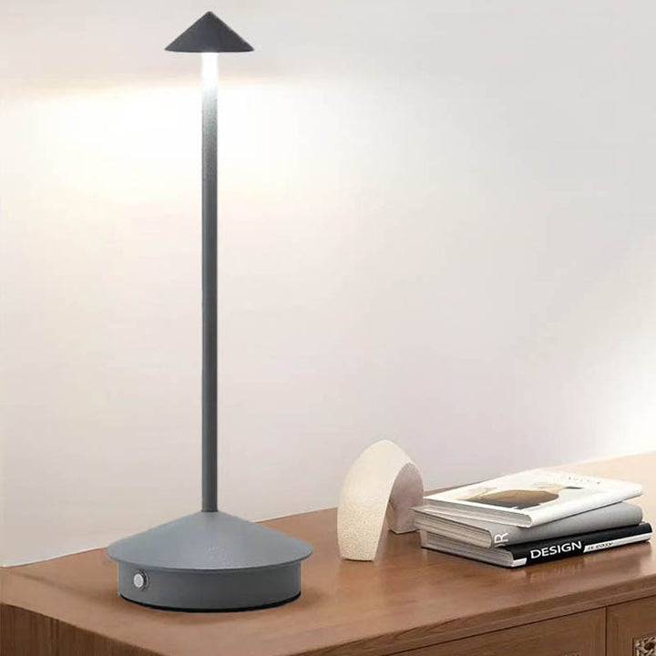 A sleek gray portable LED table lamp with a triangular shade and a circular base, powered by a USB cable.