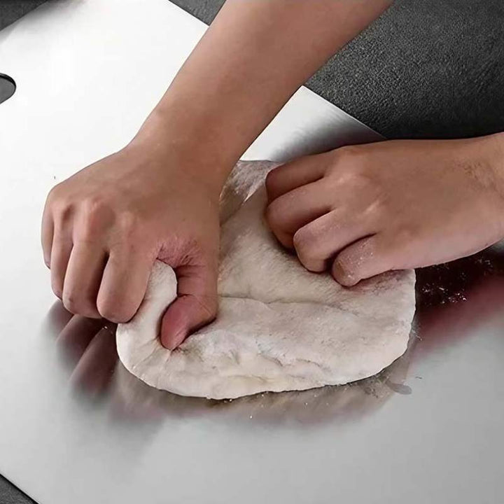 Hands kneading dough on stainless steel cutting board – durable, safe, and hygienic kitchen surface