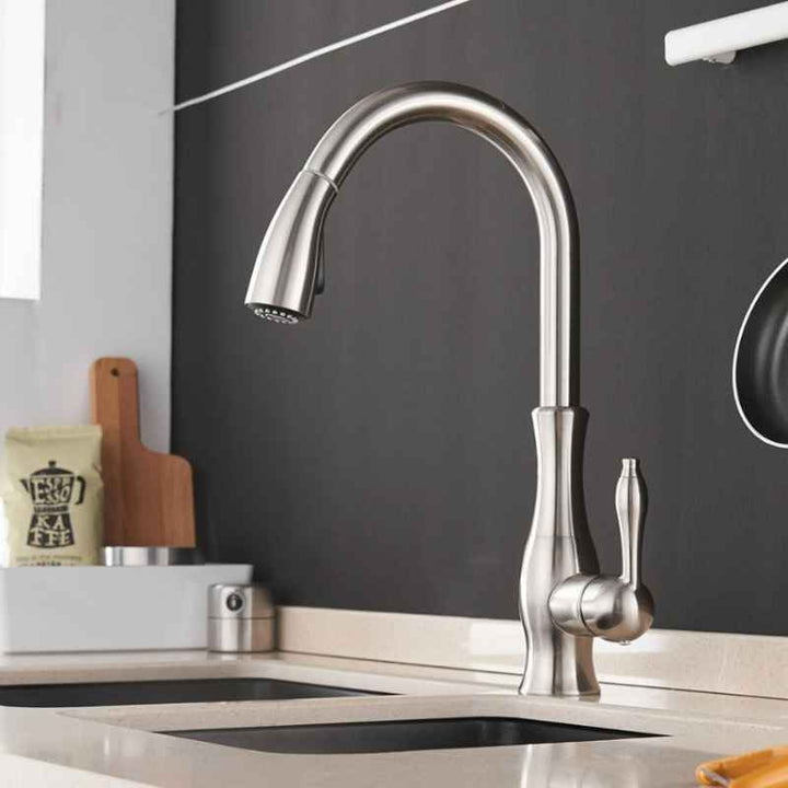 Modern kitchen faucet with a black backsplash and countertop.