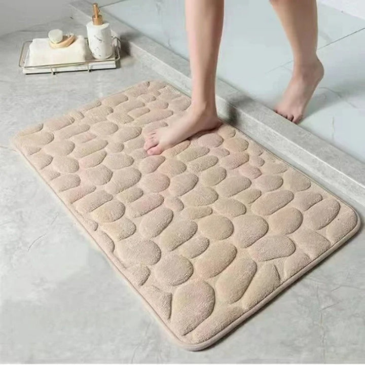 Beige bath mat with stone pattern on a bathroom floor