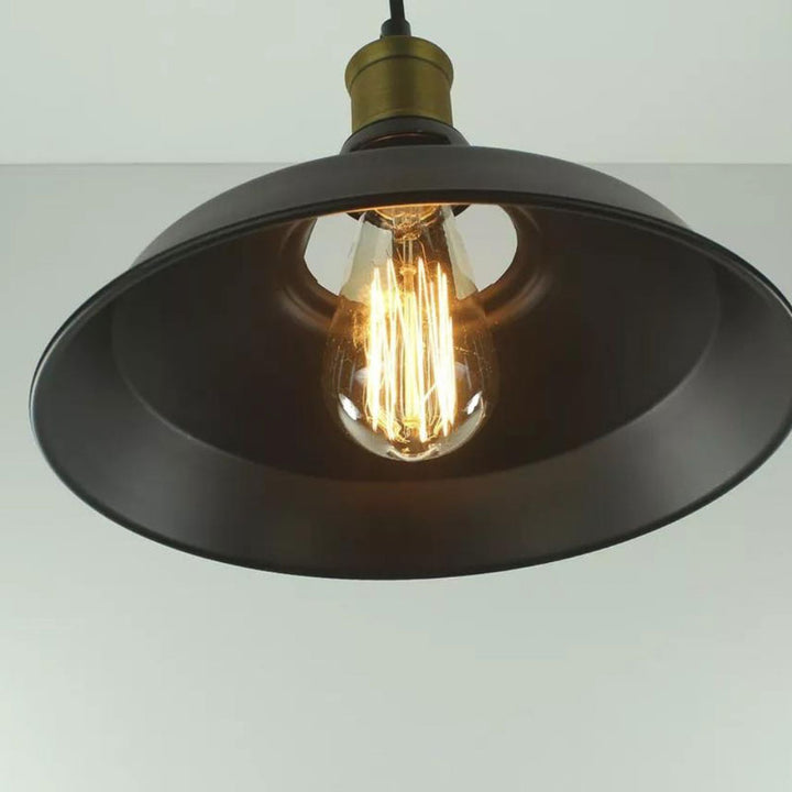 Vintage-style pendant light with a black shade and exposed bulb on a plain background