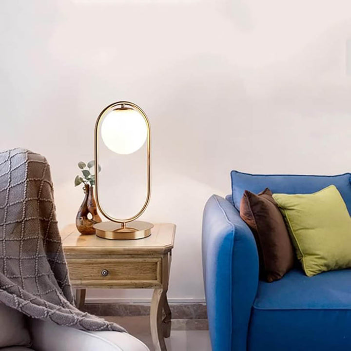 Tall brass ring table lamp with globe shade on wooden side table, modern Nordic decor for living room