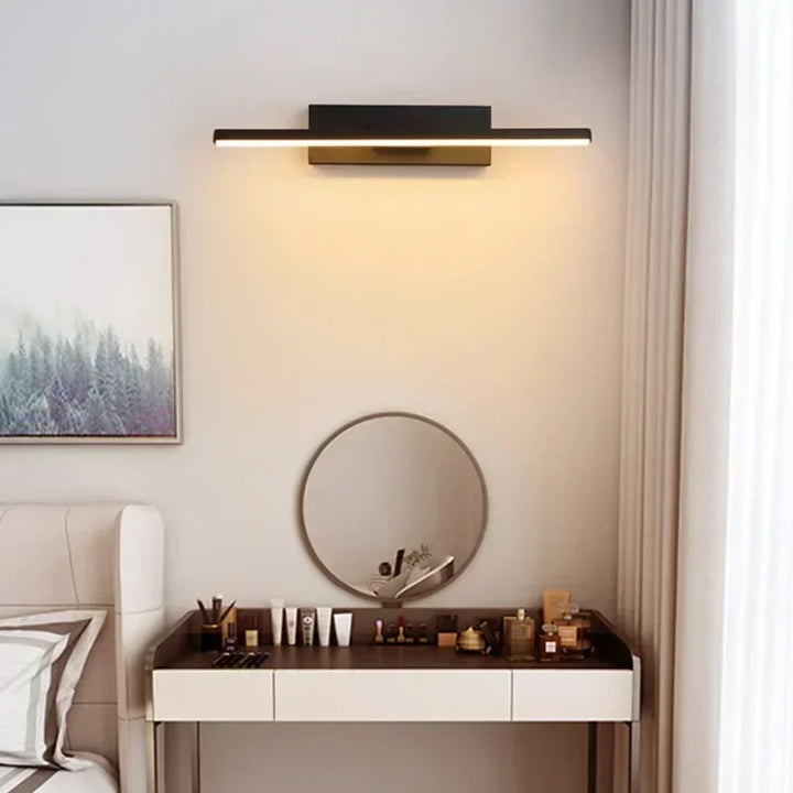 Modern rotatable wall light fixture in a bedroom setting with a mirror and vanity.