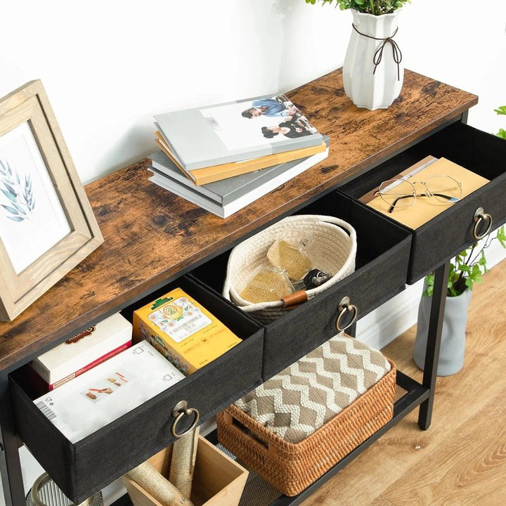 Wooden console table with drawers, books, and decorative items in a home setting.