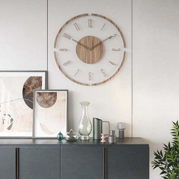 Wooden wall clock on a white wall above a gray cabinet with decorative items.