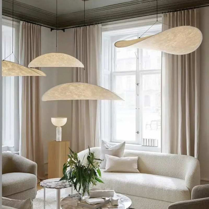 Assorted silk pendant lights in soft curved shapes displayed in a Scandinavian-inspired living room.