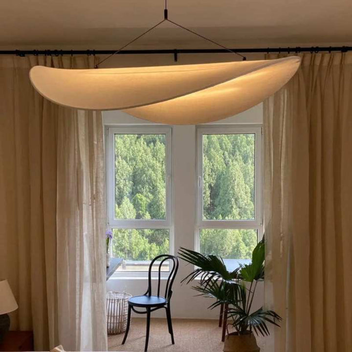 Overlapping silk pendant lights in warm tones illuminating a cozy lounge area.