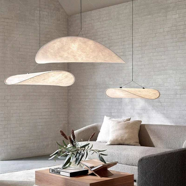 Set of three silk pendant lights in varied organic forms adding character to a modern sitting room.