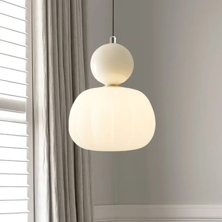 Cream Art Deco pendant light with round top accent, glowing softly in modern living room