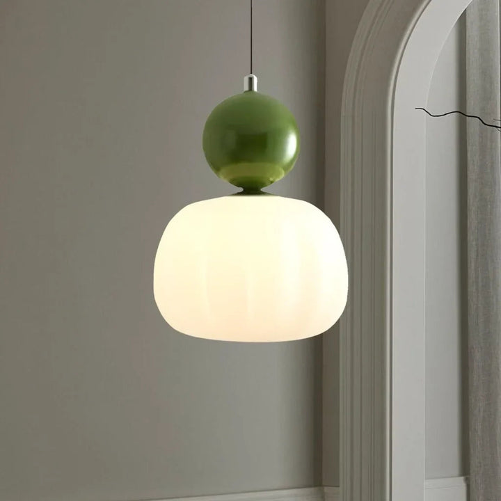 Green-accent Art Deco pendant lamp with white glass shade hanging in modern hallway
