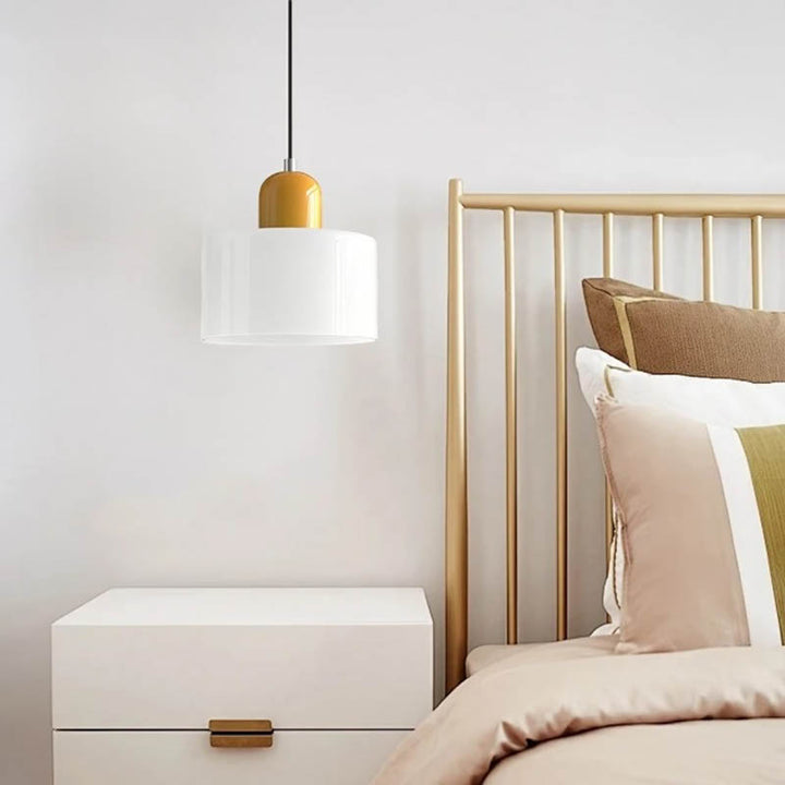 Yellow and white Nordic pendant light hanging over a wooden nightstand in a soft neutral bedroom.