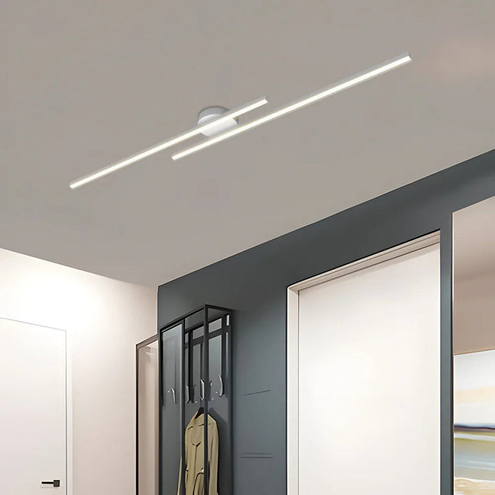 White aluminium LED strip ceiling light fixture with minimalist design, mounted in a modern hallway interior.