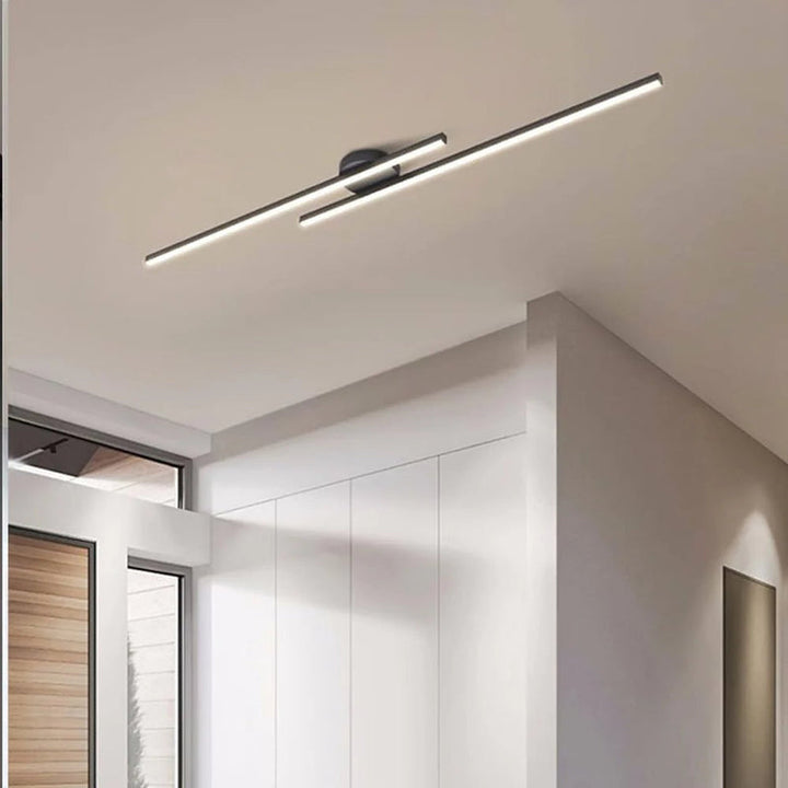 Black aluminium LED strip ceiling light mounted in modern entryway interior.