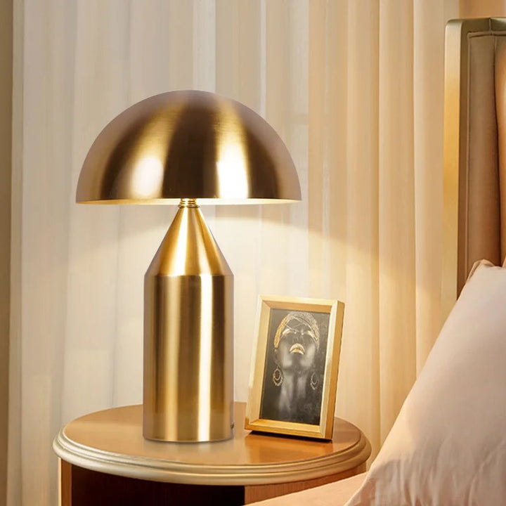 Gold SVAMPS LED lamp on black side table, adding warm Nordic elegance to living room decor.
