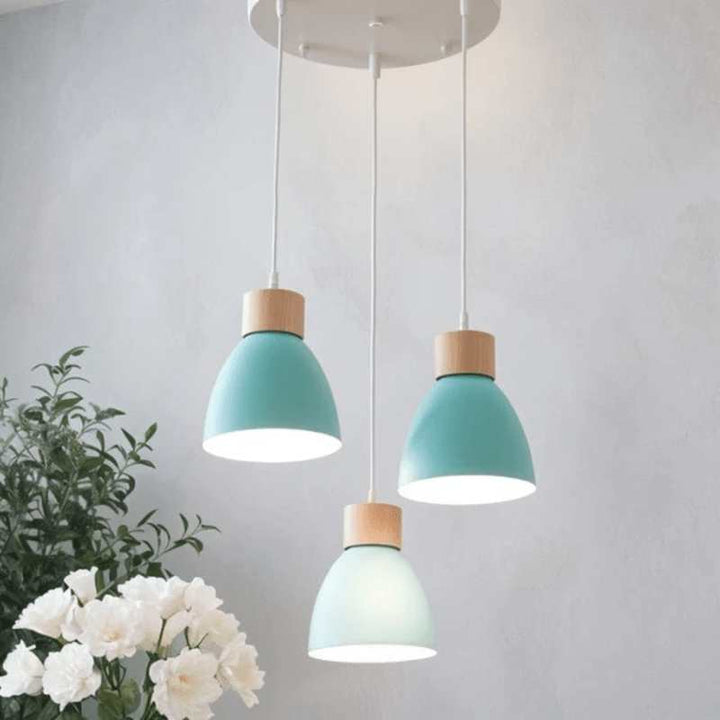 Set of three teal blue pendant lights with natural wood tops and white cords