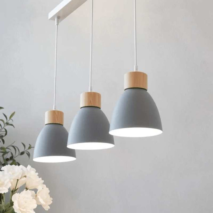 Three grey pendant lights with natural wood tops for modern dining room