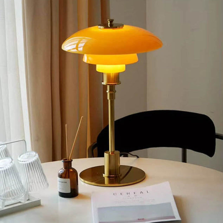 Orange Nightstand Light on a round table with a chair and decorative items in the background.