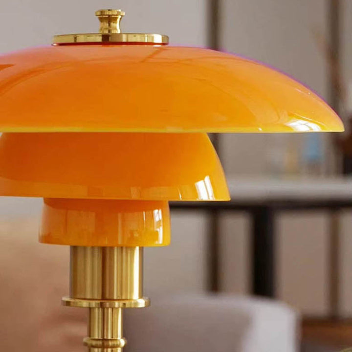Orange Nightstand Light with gold accents in a blurred indoor setting