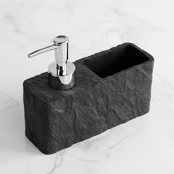 Black stone soap dispenser with chrome pump on a marble surface