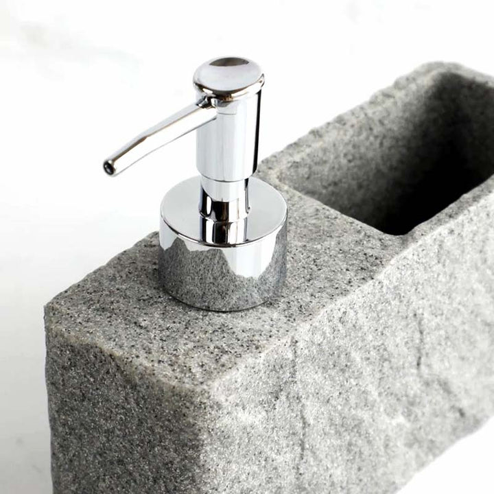 Silver soap dispenser on a concrete block