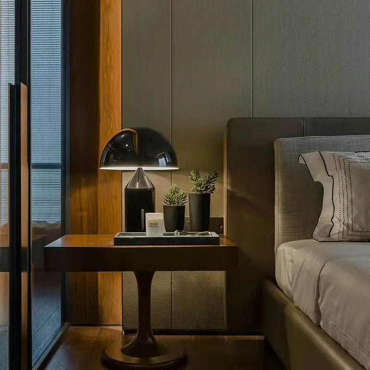 Black mushroom LED table lamp in modern bedroom setting, perfect for hotel or home use.