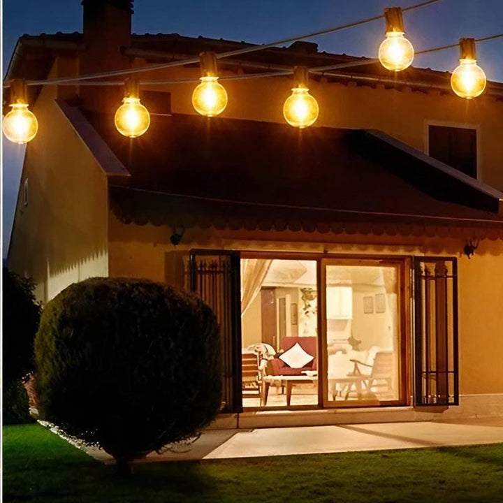 Warm LED string lights decorating outdoor garden patio, creating a cosy, romantic evening setting.