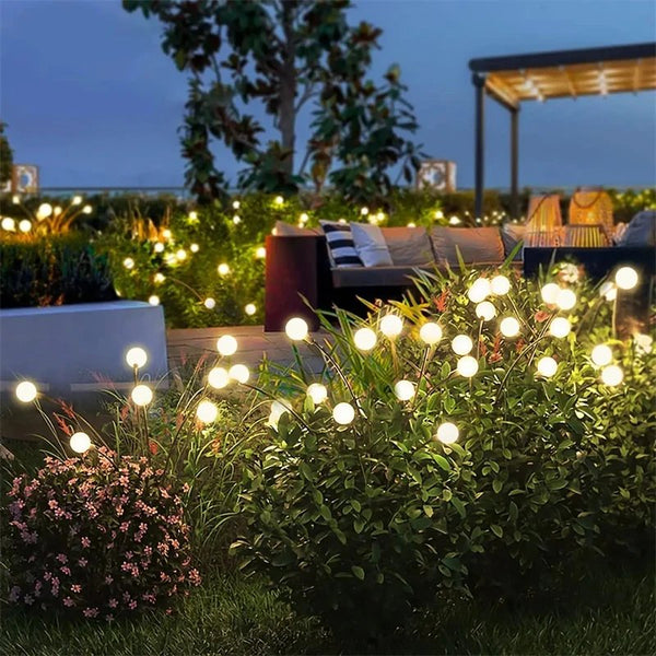 LYSGNIST solar firefly garden lights illuminating flower bed with warm LED glow for lawn decoration