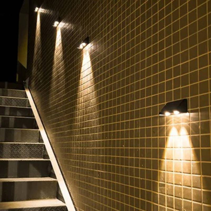 Multiple solar outdoor wall lights casting warm glow on a tiled outdoor staircase