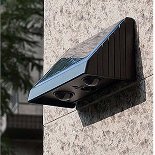 Solar-powered outdoor light fixture attached to a wall