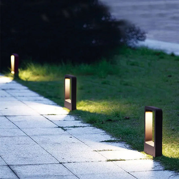 Garden pathway with solar-powered outdoor lights illuminating the grass.