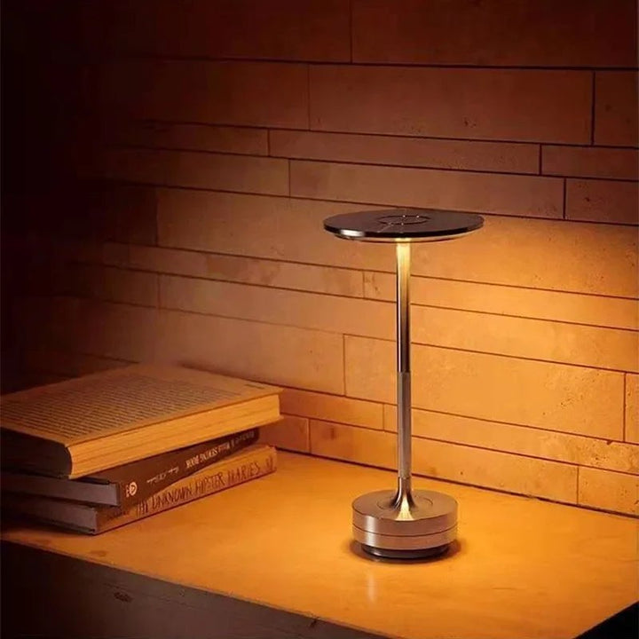 Warm ambient light from cordless gold LANTERNE table lamp, ideal for reading corner or bedside
