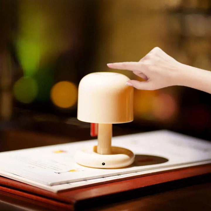 Touch-sensitive LED mushroom night light placed on an open menu, ideal for restaurant or reading table use.